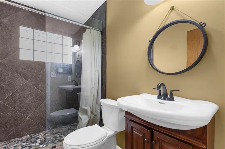 Bathroom with tiled shower and vanity
