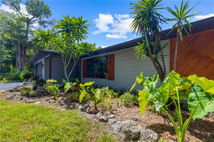View of property exterior with a garage and driveway