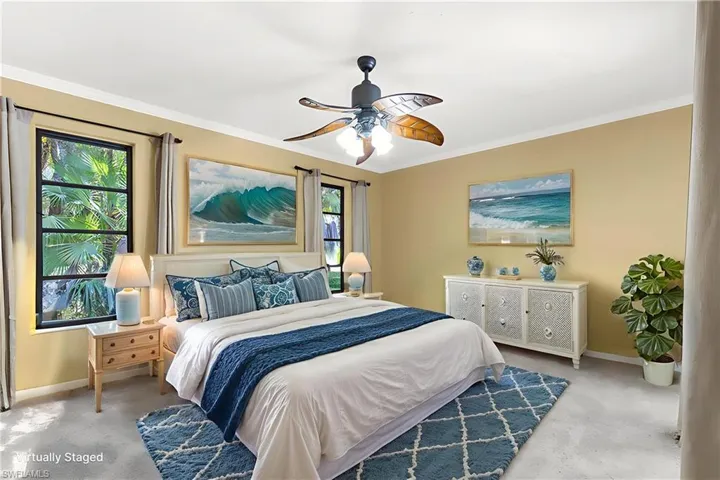 Carpeted bedroom featuring crown molding and a ceiling fan