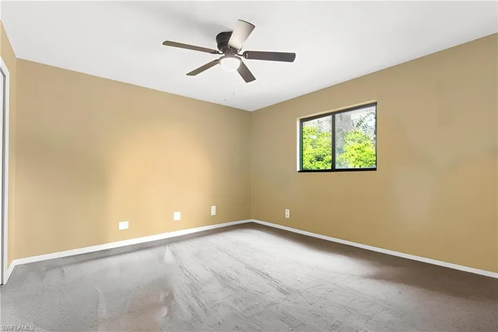 Unfurnished room featuring carpet floors and ceiling fan
