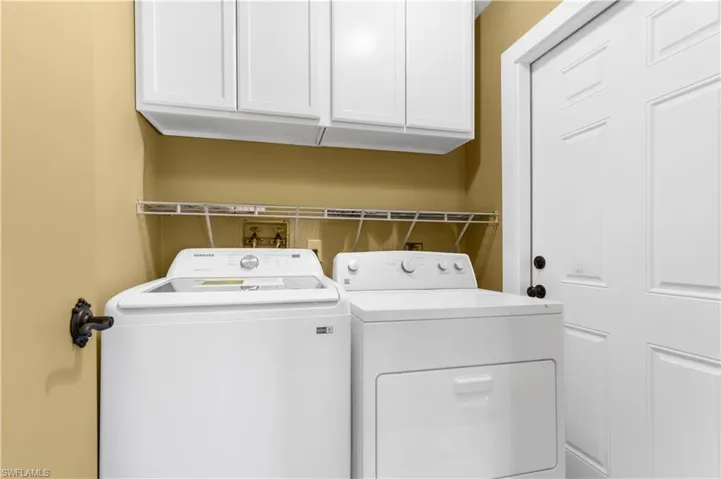 Laundry room featuring washing machine and clothes dryer and cabinet space
