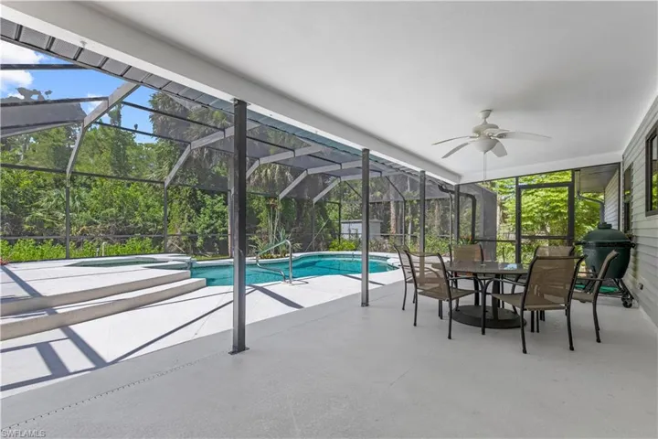 View of pool with a patio, outdoor dining space, a ceiling fan, and a pool with connected hot tub