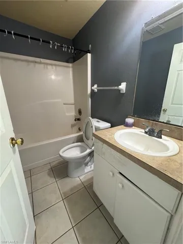Full bathroom with vanity, tub / shower combination, and tile patterned floors