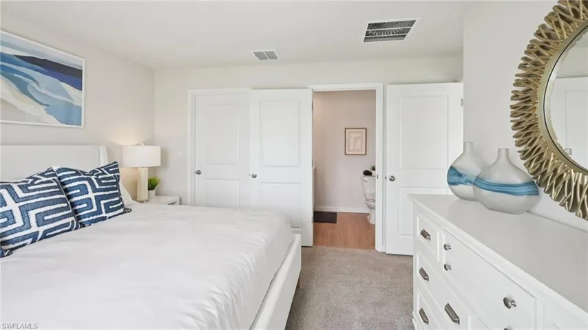 Model Home. The bedroom features light-colored walls and carpeted flooring