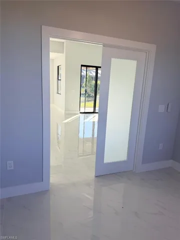 Spare room with light marble finish flooring and baseboards