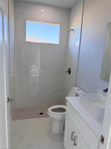 Full bath featuring a marble finish shower, vanity, and marble finish floors