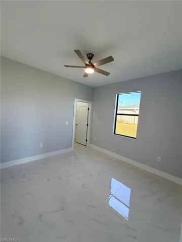 Spare room with light marble finish flooring and baseboards