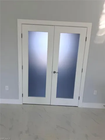 Detailed view of baseboards and french doors