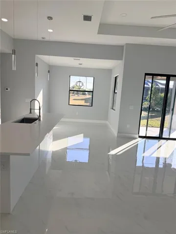 Unfurnished living room with light marble finish floors, recessed lighting, and ceiling fan