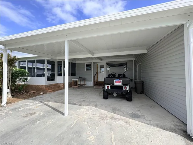 View of vehicle parking with an attached carport and driveway