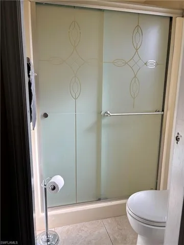 Full bath featuring a stall shower and toilet