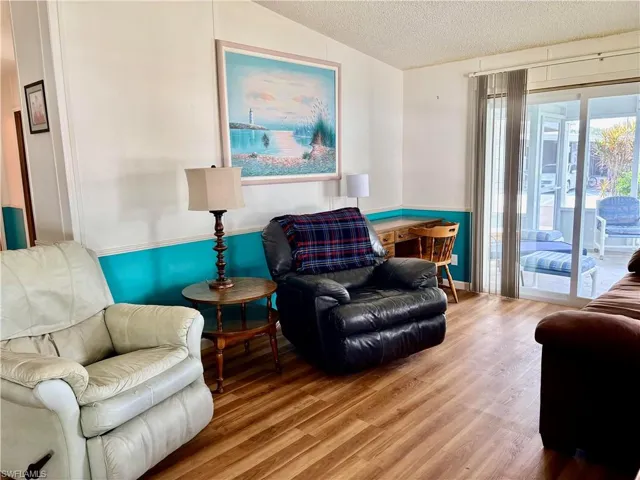 Sitting room with a textured ceiling and wood finished floors