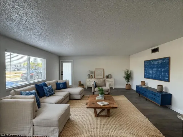 Living room with wood finished floors and a textured ceiling