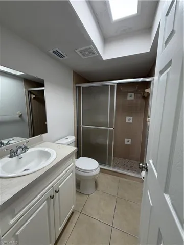 Full bathroom with vanity, a shower stall, and light tile patterned flooring