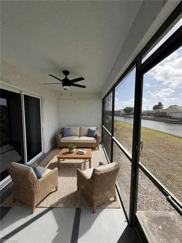 Sunroom / solarium with ceiling fan, an outdoor living space, and a water view