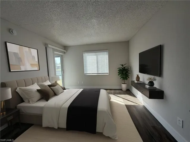 Bedroom with wood finished floors and a textured ceiling