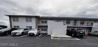 View of apartment building / complex featuring uncovered parking