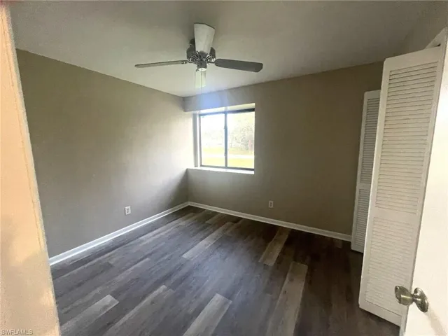 Unfurnished bedroom featuring dark wood-type flooring, ceiling fan, and a closet