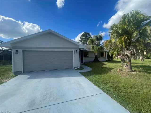 Single story home featuring a garage and a front lawn