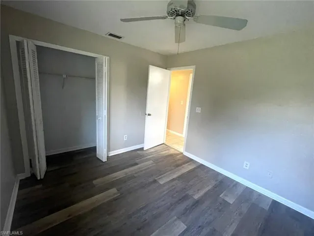 Unfurnished bedroom with a closet, ceiling fan, and dark hardwood / wood-style floors
