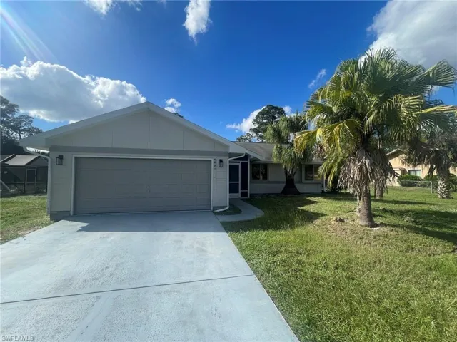 View of front of home with a garage and a front yard
