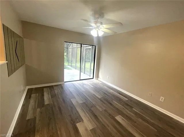 Empty room with dark wood-type flooring and ceiling fan