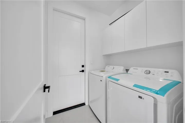 Laundry room featuring cabinet space and washer and clothes dryer