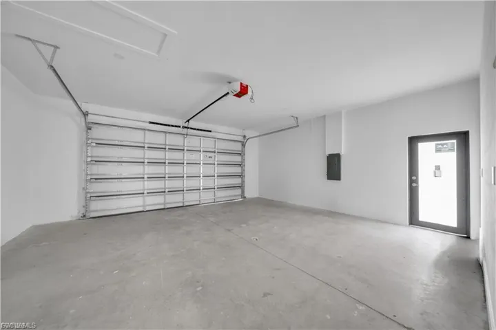 Garage with electric panel and a garage door opener