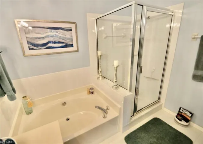 Bathroom featuring a bath, a stall shower, and tile patterned floors