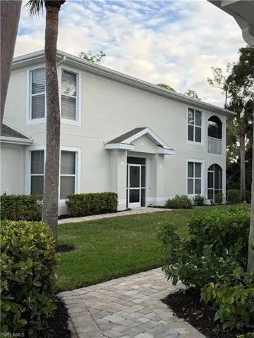 View of front facade with stucco siding and a front lawn
