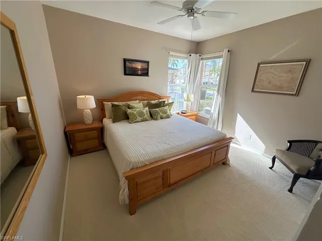 Carpeted bedroom featuring a ceiling fan and baseboards