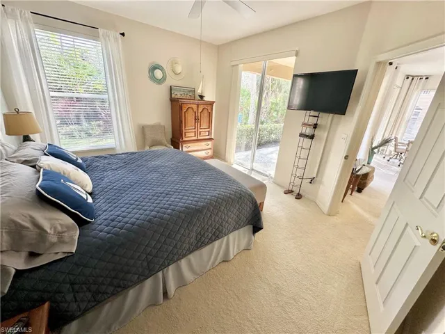 Bedroom featuring access to outside, light carpet, and multiple windows