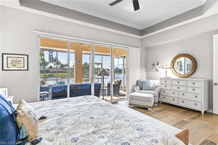 The primary bedroom offers direct access to the screened-in lanai, allowing you to start each day surrounded by serene views. Featuring tray ceilings, an oversized layout, and a comfortable seating area, this retreat blends space and elegance with ease.