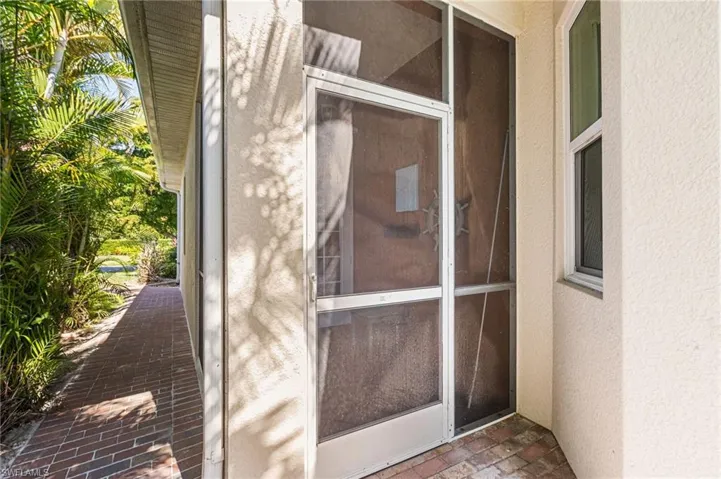 This screened-in lanai, located just off the second bedroom, offers a quiet and private outdoor retreat. A newly added brick walkway provides convenient side entry to the home, allowing for discreet access without disturbing other guests.