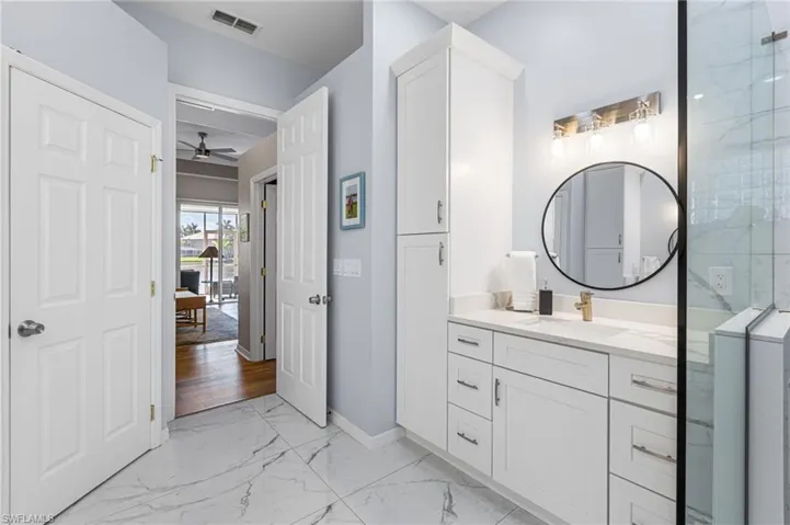 His-and-hers separate vanities topped with soothing granite offer both comfort and style, creating a well-appointed space designed for ease and everyday luxury.