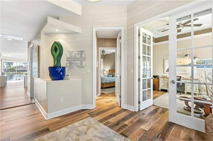 As you enter the home, your attention is immediately drawn to the serene water views. Just beyond, elegant French doors open to the third bedroom/office, featuring double glass French doors of its own, while the second bedroom is conveniently located just down the hall.