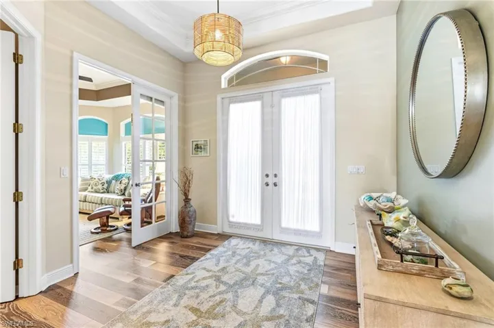 Eight-foot French glass doors with transom windows and a tray ceiling set the tone as you step inside, offering an elegant first impression that says, “yes, this home really is this good.”