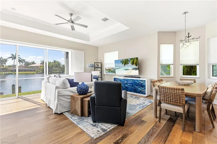 The spacious, open, and airy living room showcases sweeping lake views, enhanced by pocketing sliders that create seamless indoor-outdoor living. Soaring ceilings with elegant tray accents complete the refined, light-filled space.