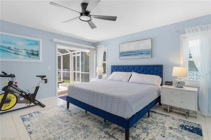 Tiled bedroom with ceiling fan and multiple windows