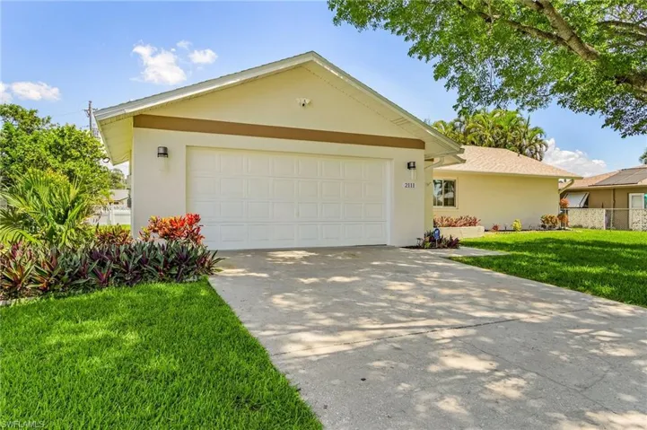 Single story home with a front yard and a garage