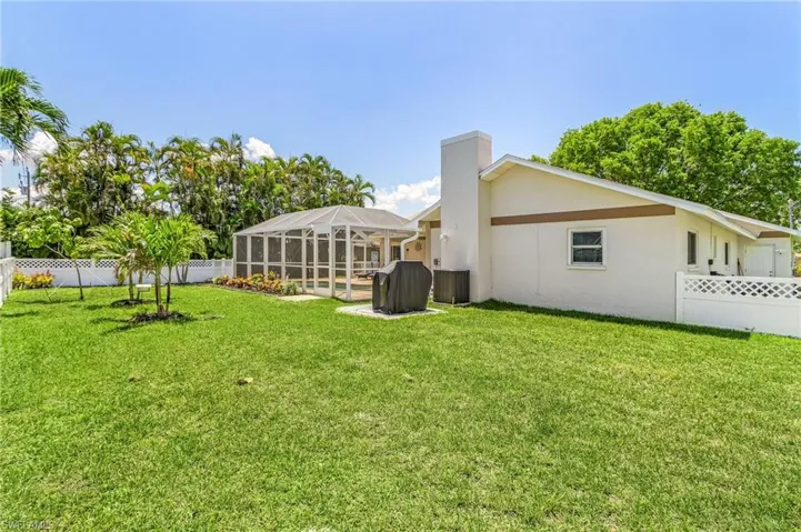 View of yard featuring a swimming pool, glass enclosure, and central air condition unit
