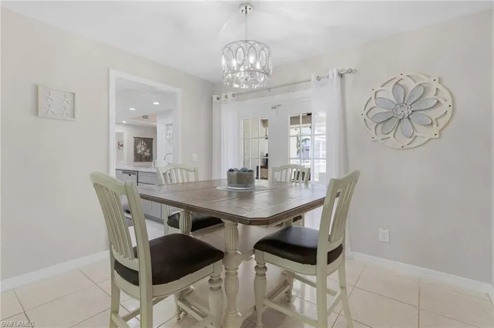 Tiled dining room with a chandelier