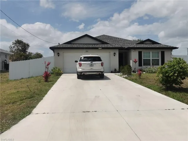 Ranch-style home with driveway, a garage, stucco siding, and roof with shingles