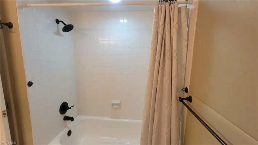 Bathroom featuring shower / bathtub combination with curtain