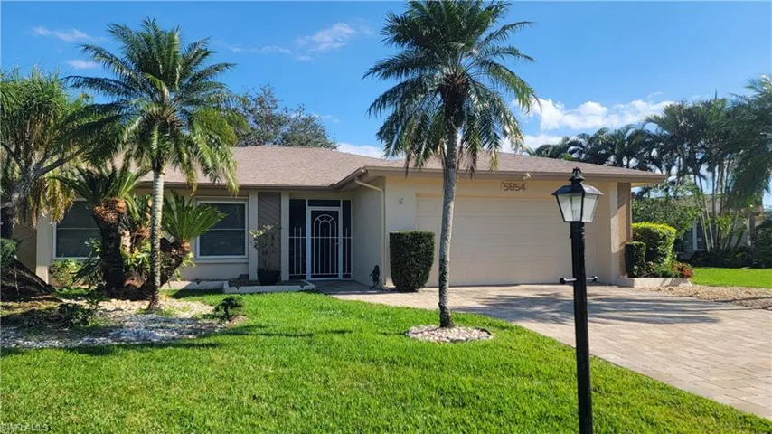Ranch-style home with a garage and a front yard