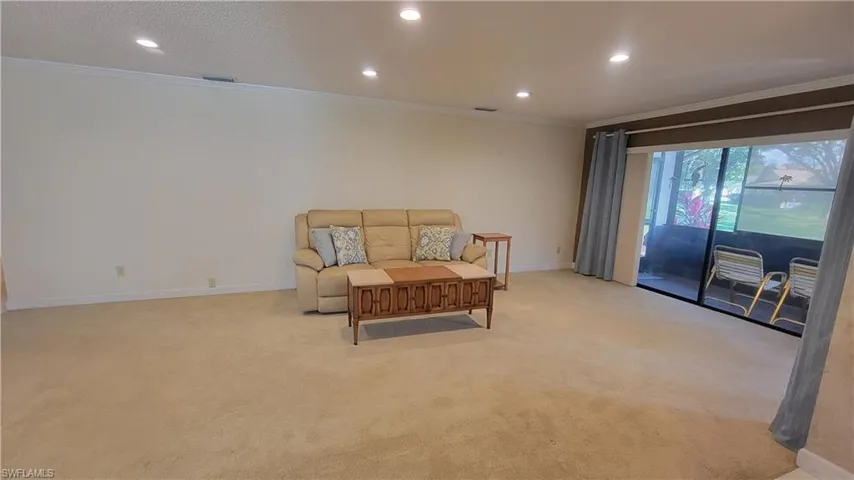 Sitting room featuring light colored carpet and ornamental molding