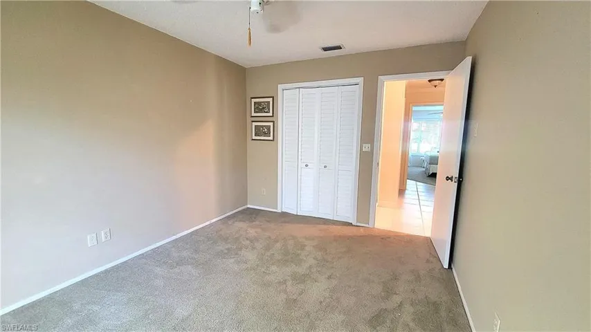 Unfurnished bedroom with carpet floors, ceiling fan, and a closet