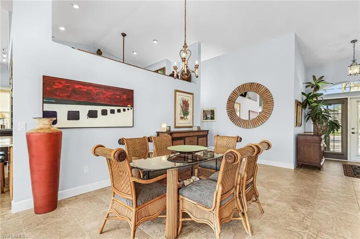 Dining area with a chandelier and high vaulted ceiling