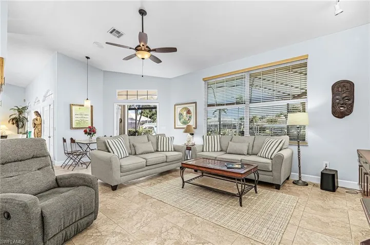Living room with a ceiling fan and lofted ceiling