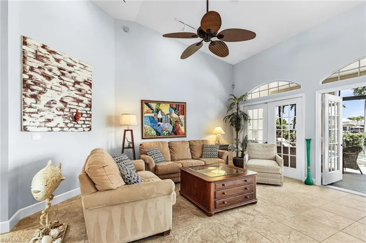 Living area featuring high vaulted ceiling, ceiling fan, and french doors